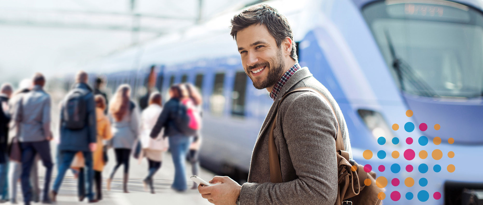 Mann mit Smartphone vor einem Zug