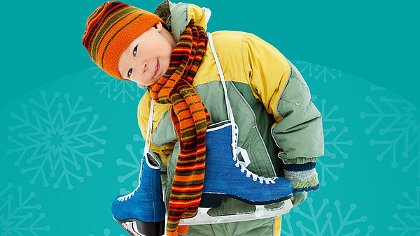 Kinder in Wintersachen mit blauen Schlittschuhen lächelt in die Kamera