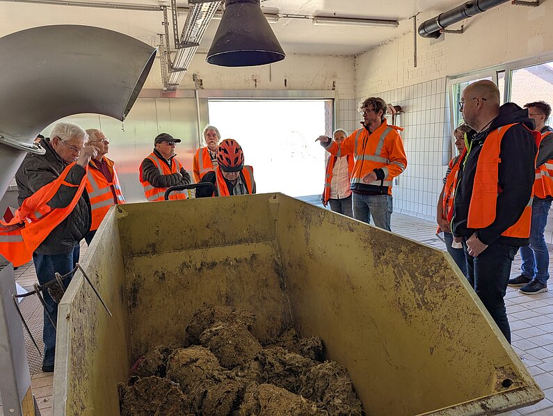 GRuppe in orange-farbenen Westen bei Führung in Rechenanlage.