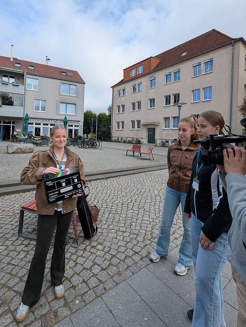 Mädchen mit Filmklappe am Set.