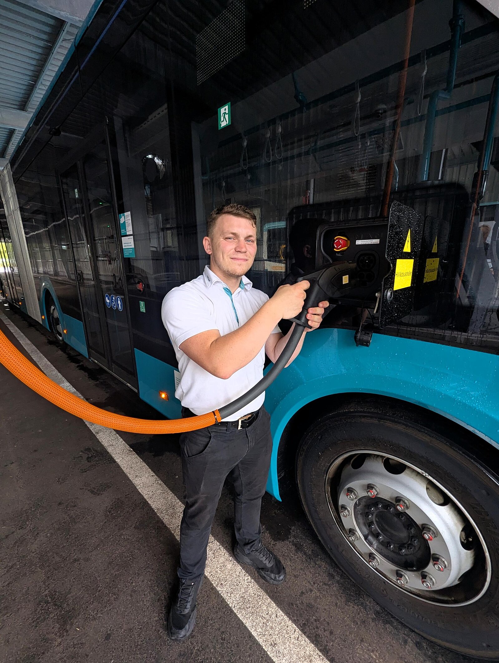Ein Busfahrer Lädt einen E-Bus.