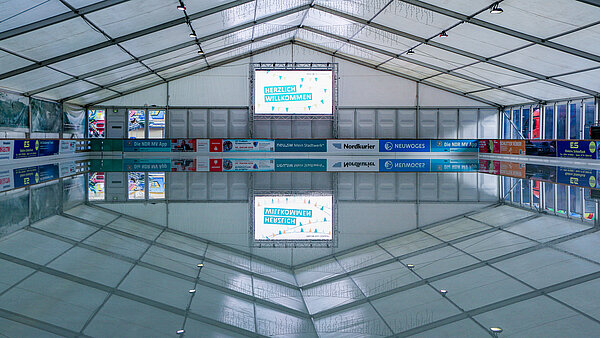 Leere Eisfläche mit Spiegelung in der Eislaufhalle