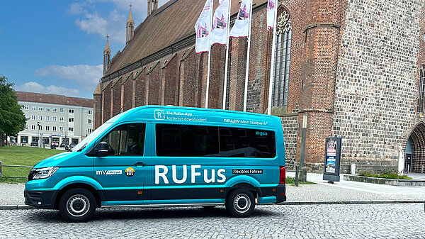 türkis beklebter Rufus Sprinter vor der Marienkirche Neubrandenburg