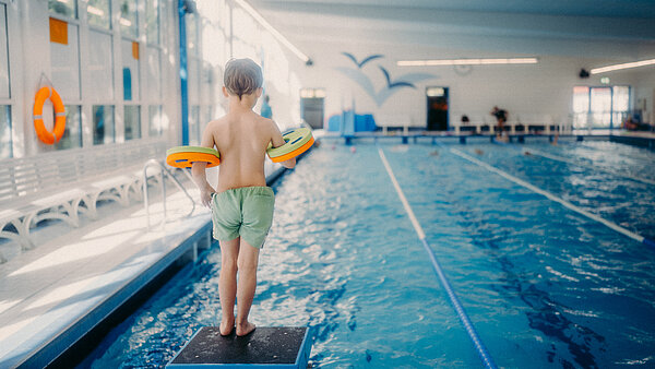 Ein Junge bereitet sich auf einen Sprung ins Wasser vor 