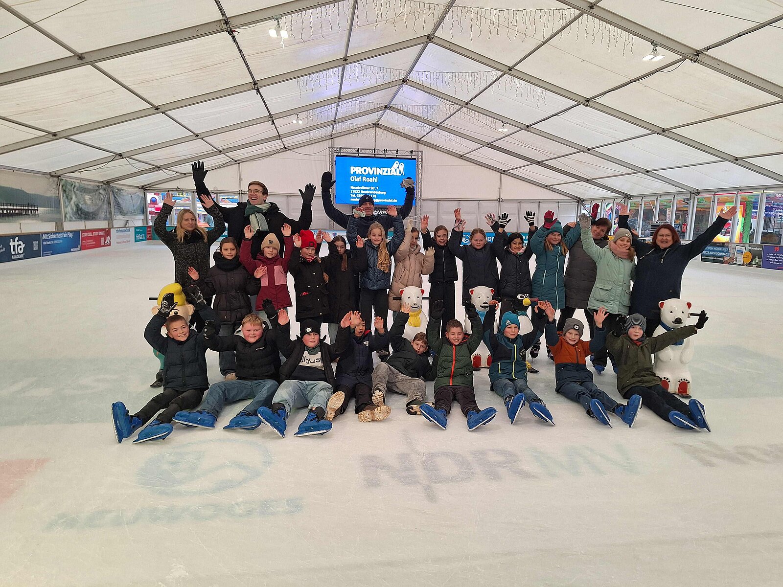 Gruppenfoto auf einer Eislauffläche.