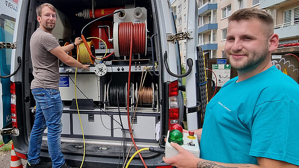 neu.sw Mitarbeiter am geöffneten Kabelmesswagen. Man sieht unterschiedlichste Kabelrollen mit Kabeln.