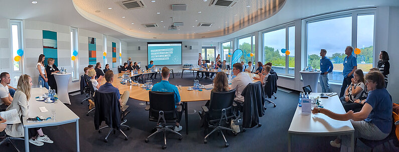 Panorama-Aufnahme des neu.sw Konferenzraums mit Gästen.