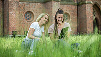 Zwei junge Frauen schauen sich etwas gemeinsam auf einem Tablet an