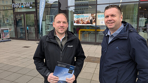 Experten Stefan Lange und Jan Böttcher vor dem neu.sw Kundenbüro auf dem Marktplatz.