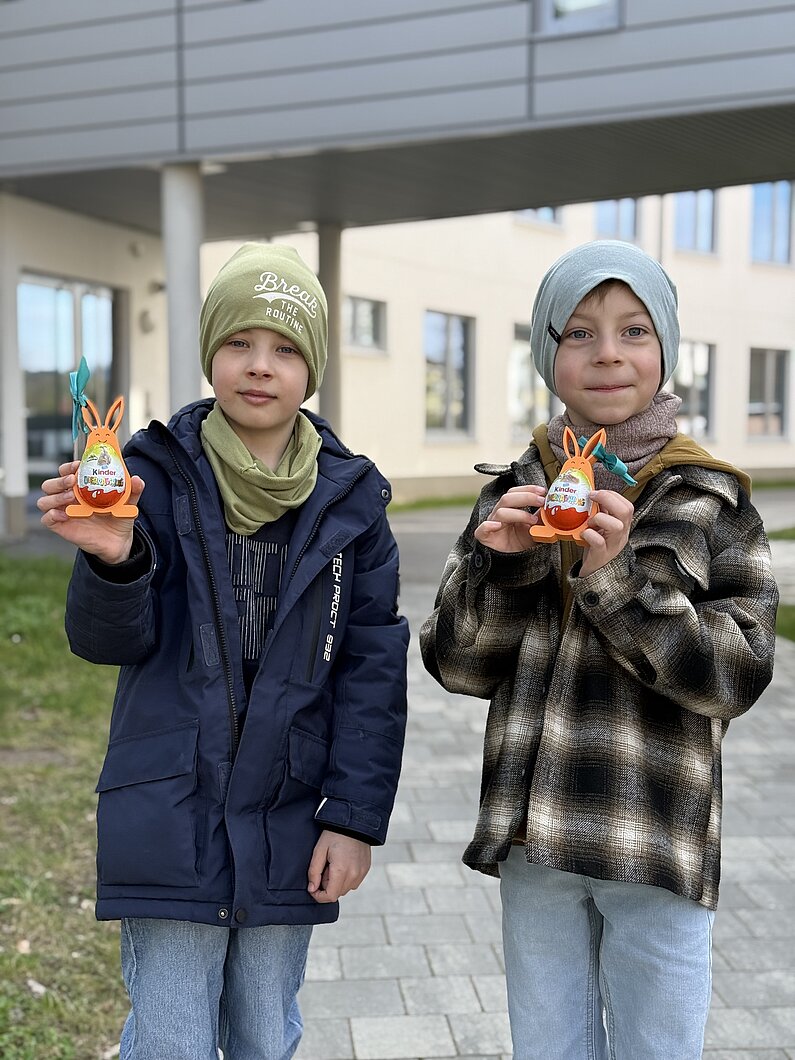 Zwei Jungen aus der neu.sw Patenklasse halten lächelnd ihre Osterhasen in die Kamera.