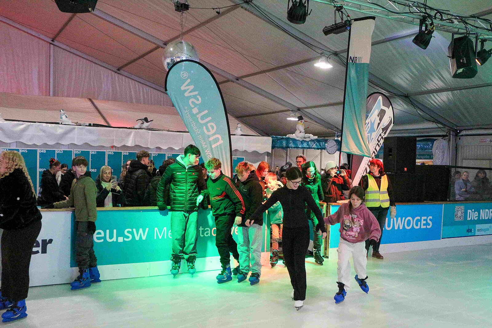 Menschen auf einer Eislauffläche.