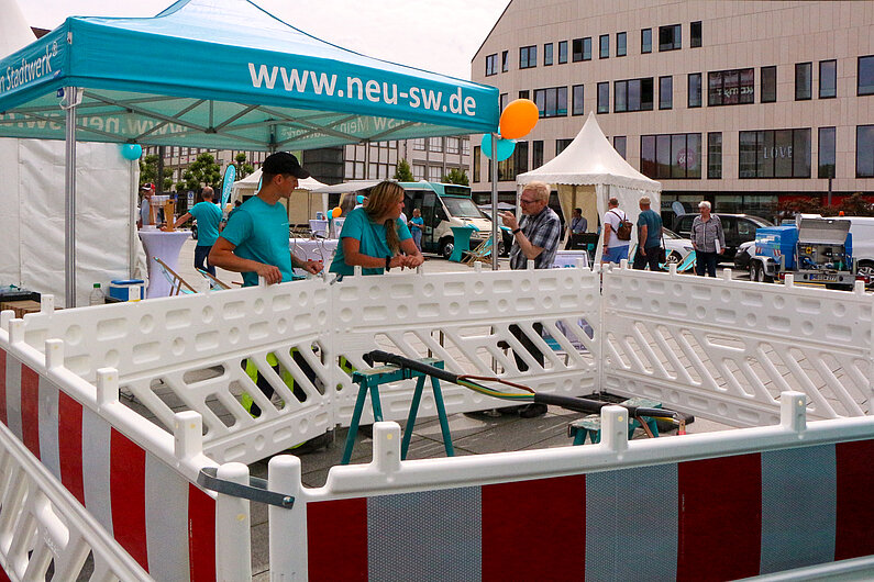 Baustellenabsperrung auf dem Markt mit Mitarbeitern und Kunden.