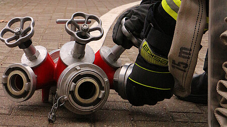 Hände ein einer Feuerwehrschual-Kupplung
