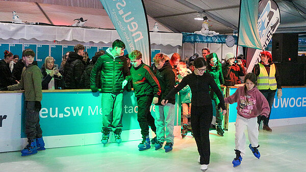 Jugendliche streben auf die Eisfläche.