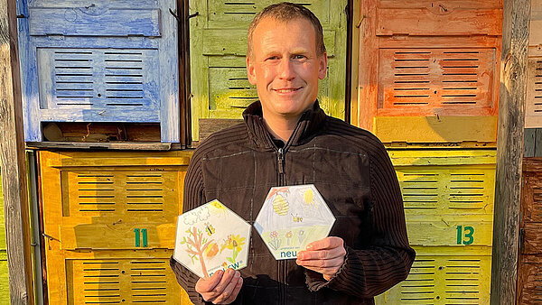 Imker steht vor seinen Bienenwaben