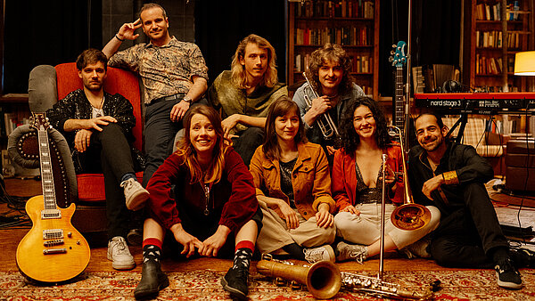 Bandfoto The Keeds sitzend mit Instrumenten.