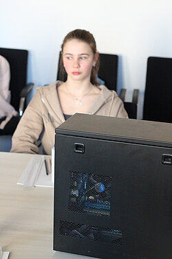 Junge Frau hinter einem PC-Gehäuse.