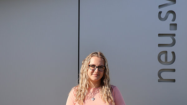 Junge Frau vor dem neu.sw Schriftzug