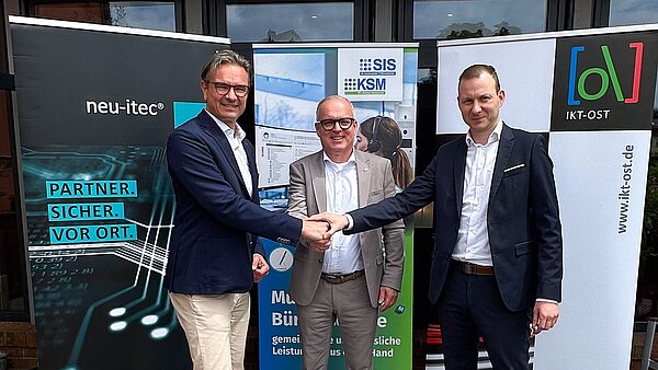 Chefs der beteiligten IT-Unternehmen legen ihre Hände zusammen.