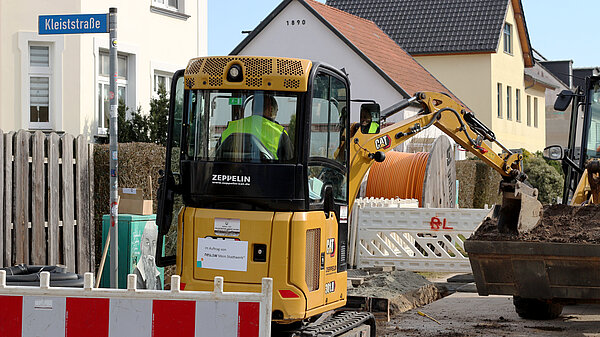Baustelle mit Bagger vor Glasfaserkabel-Trommel im Jahnviertel.