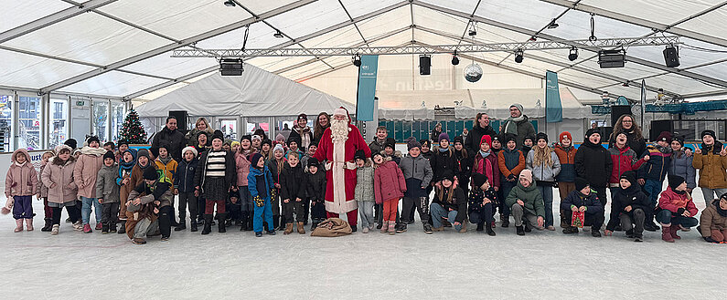 Gruppenbild aller Klassen, Lehrer und Paten auf der Eislauffläche der neu.sw Eislaufhalle. 