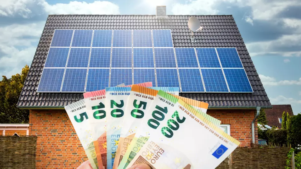 Geldscheine und Solaranlage auf dem Dach 