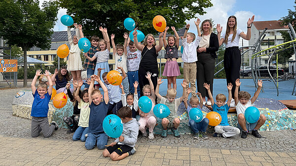 Gruppefoto einer Grundschulklasse mit Luftballons.