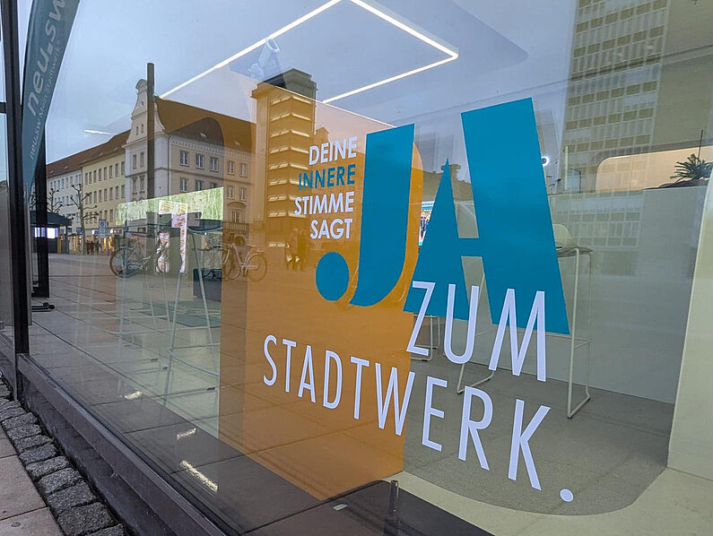 Blick auf die fertige Beklebung mit der Aufschrift JA (in türkis) ZUM STADTWERK (in weiß). 
