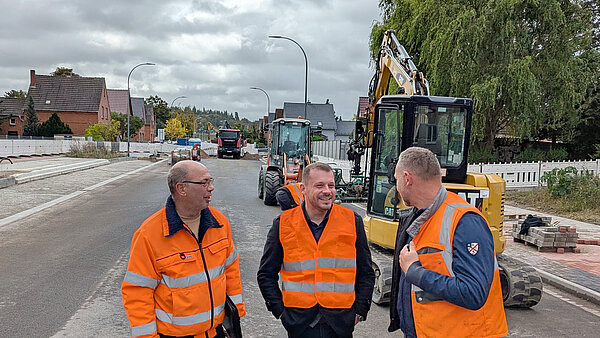 Zwei Projektverantwortliche auf der Baustelle im Gespräch mit Oberbürgermeister Niko Klose. 