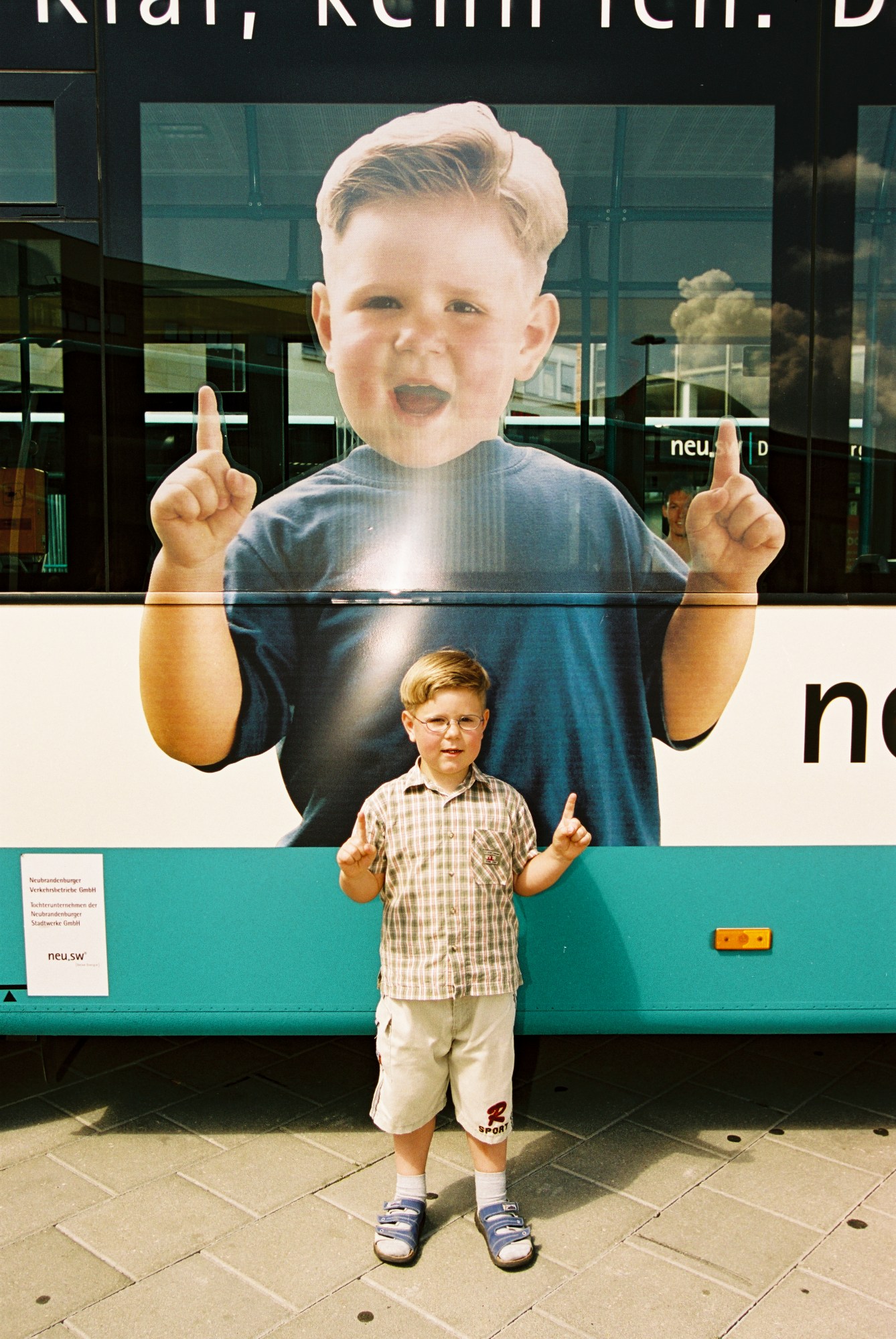 Ein Kind von einem Bus mit einem Bild von sich selbst auf dem Bus.