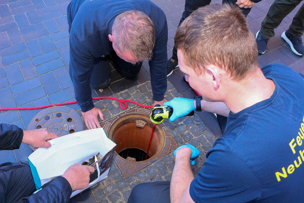 Männer an einem Schacht.