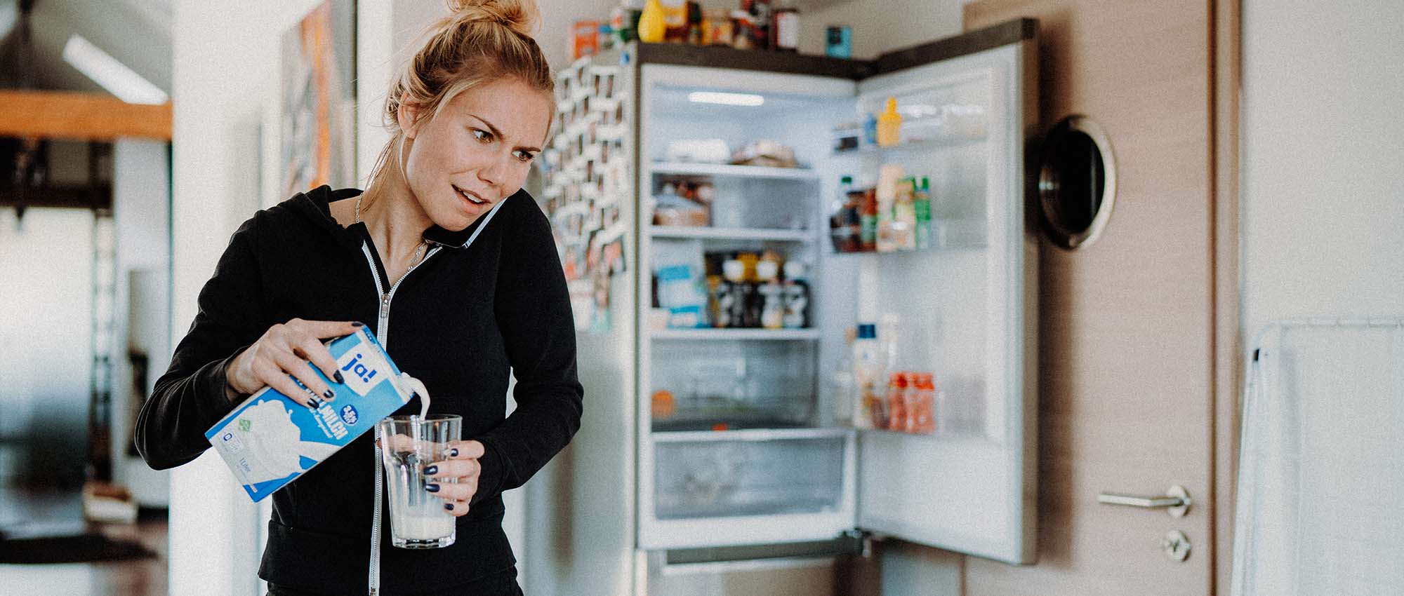 Frau am Kühlschrank mit Paprika in der Hand