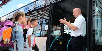 Busfahrer erklärt Kindern etwas