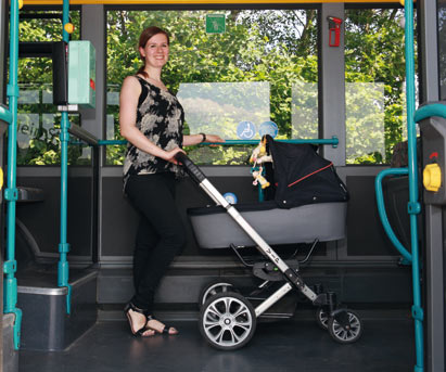Frau mit Kinderwagen steht auf dem dafür vorgesehenen Stellplatz